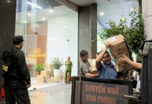 Police Remove Sealed Boxes from Building Housing Shark Binh’s Company Headquarters